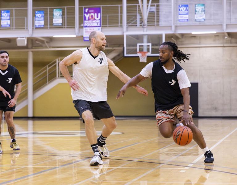 Action shot of a YMCA basketball player driving the ball to the key.