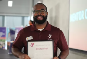 YMCA mentor of the year, Dionte Simon, smiling with his award.