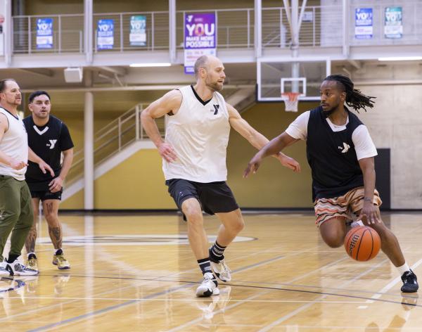 Action shot of a YMCA basketball player driving the ball to the key.