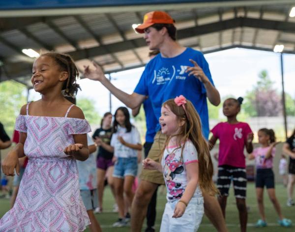 Summer camp participants dance during music time at the YMCA