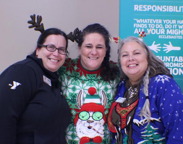 Child Care staff post in festive holiday sweaters and reindeer antlers at the YMCA