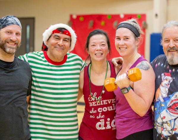 12 Days of FITmas participants pose in Holiday apparel and pose after a holiday themed circuit workout at the YMCA.