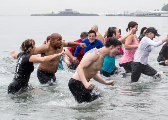 People run away from the cold Puget Sound at the Plunge event