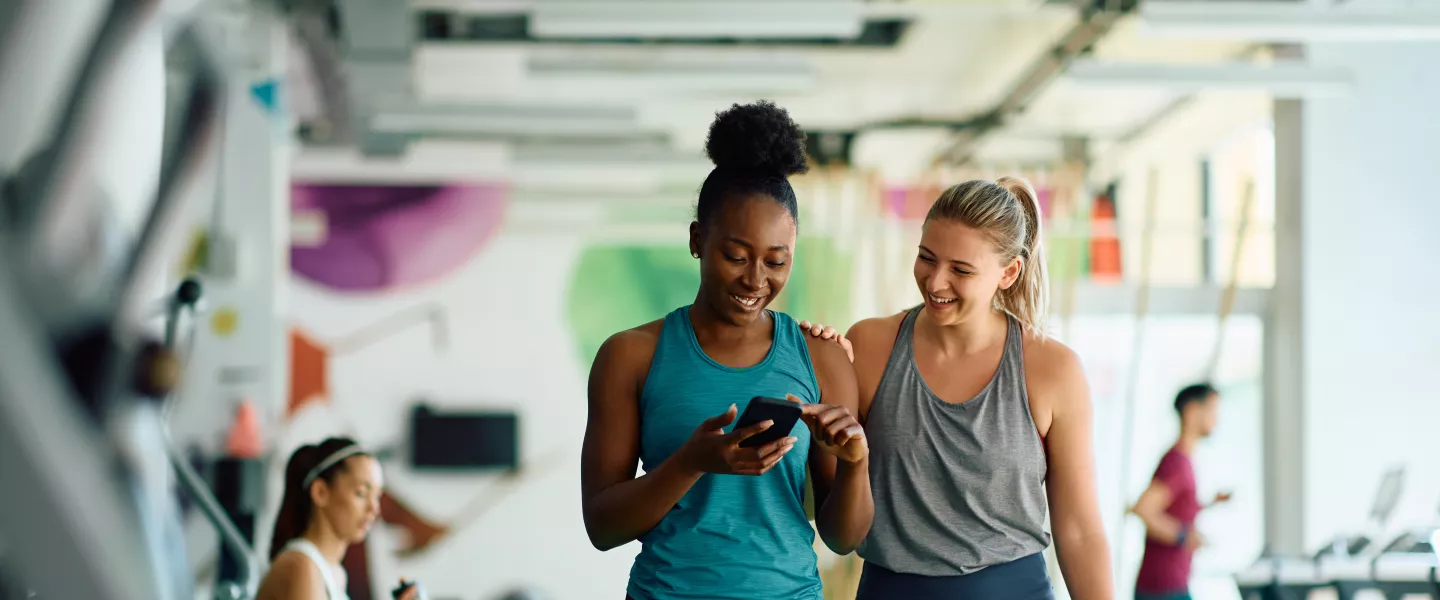 Friends checking workouts on their phone at the YMCA