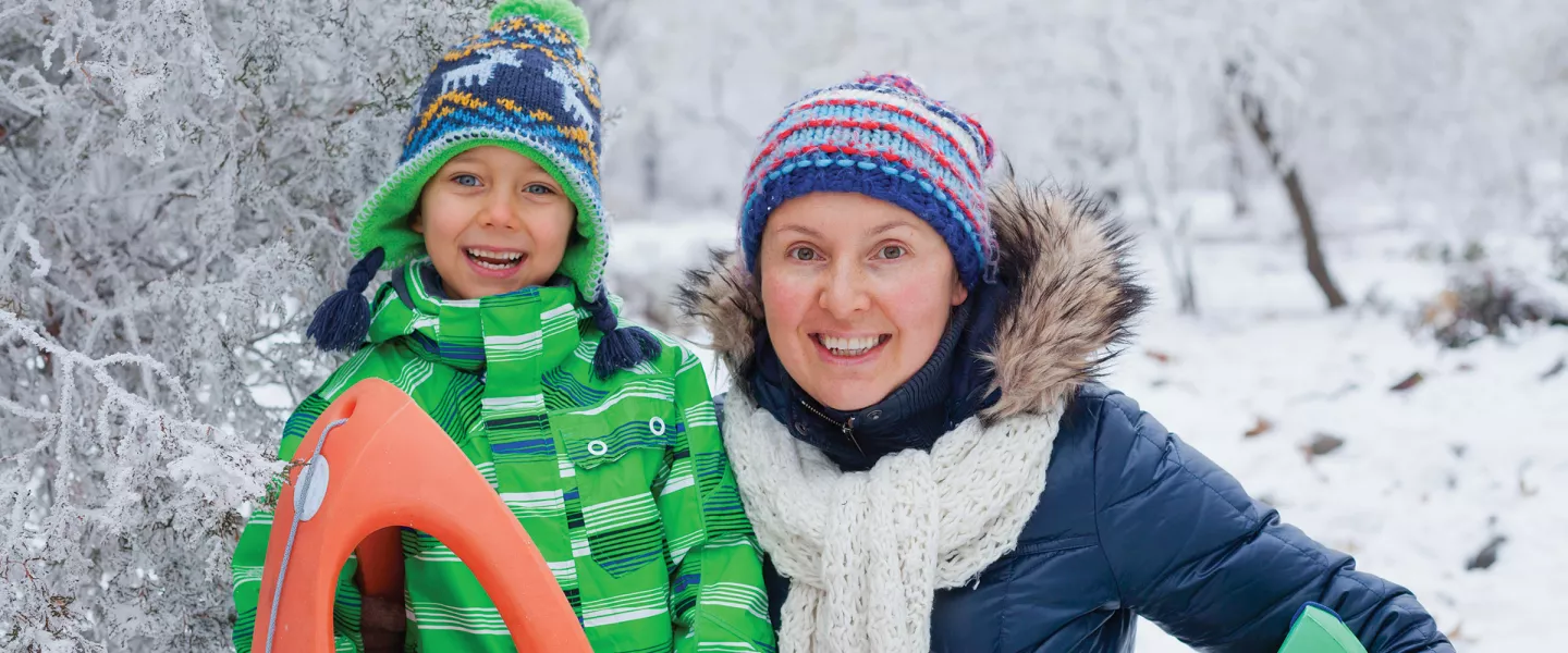 Mother and Son Smiling on Snowy Hill