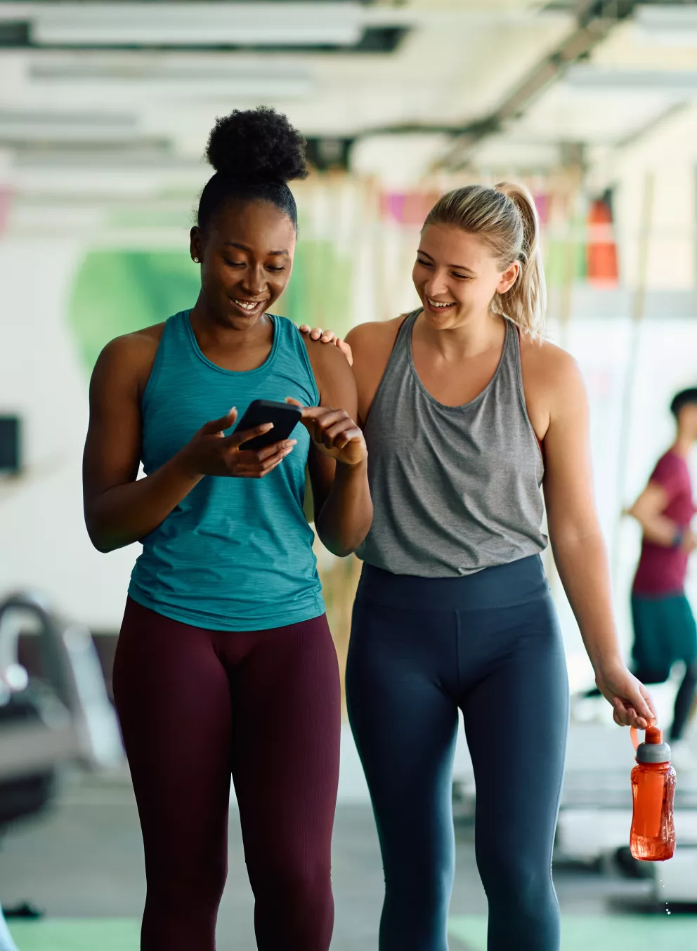 Friends checking workouts on their phone at the YMCA