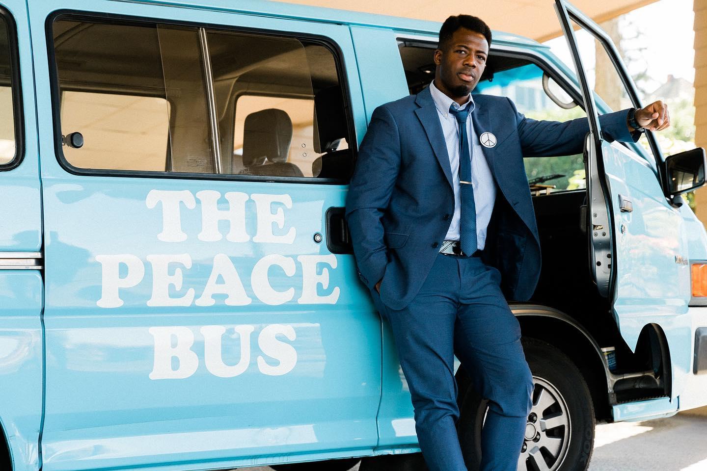 Kwabi stands in front of the Peace Bus
