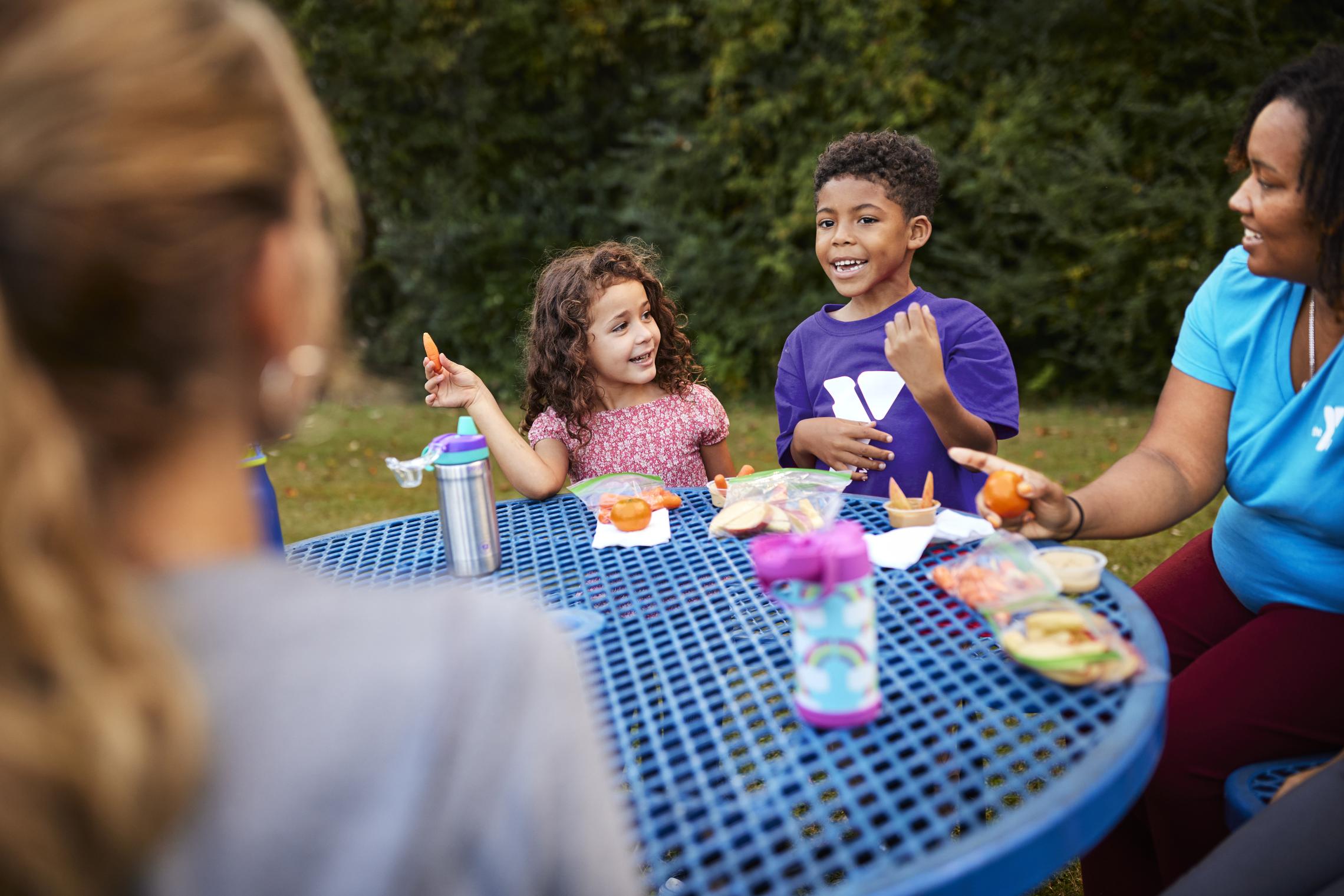 Campers enjoy snack time outside at the YMCA
