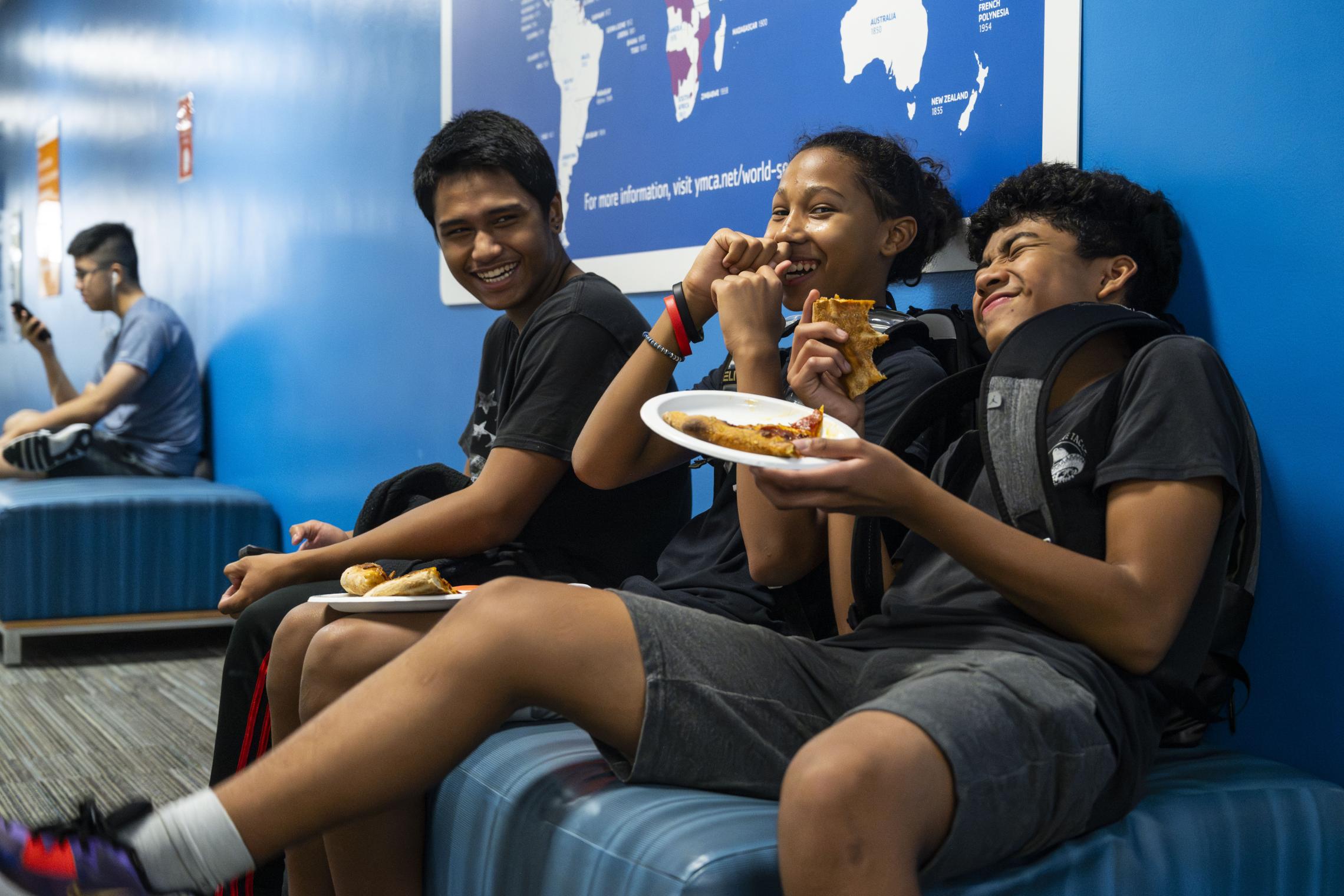 Late Nite Teens laugh over some slices of pizza at the YMCA