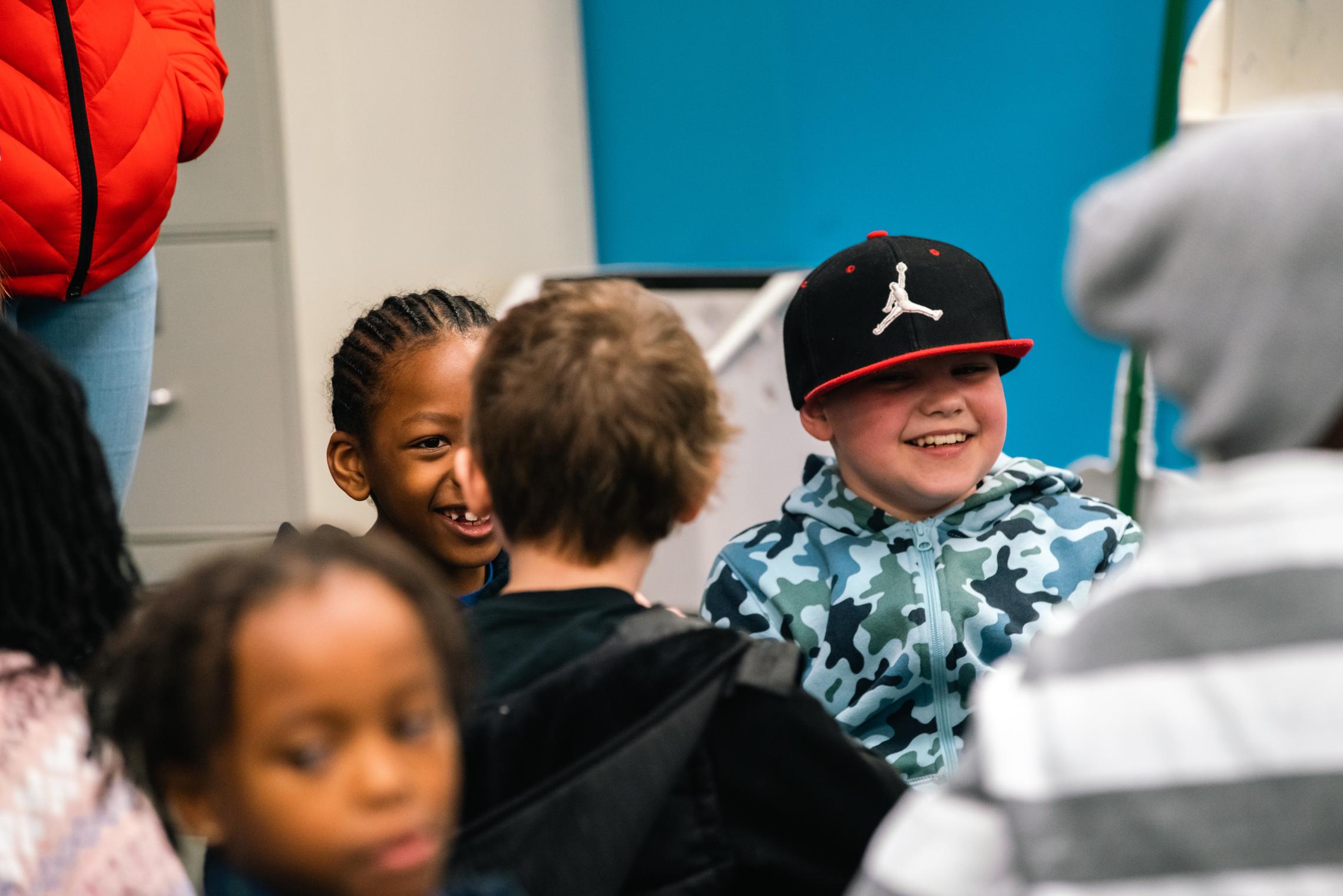 Child watch participants smile during a group game at the YMCA