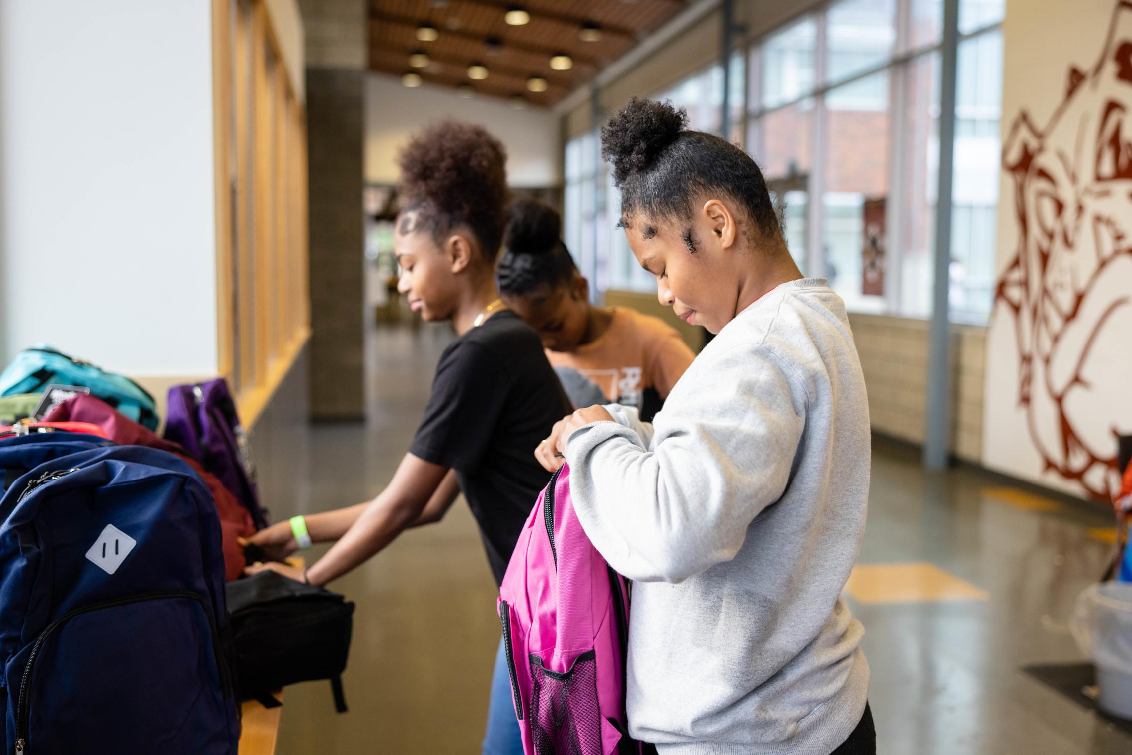 Late Nite students select from a variety of free backpacks containing school supplies at the YMCA back to school event