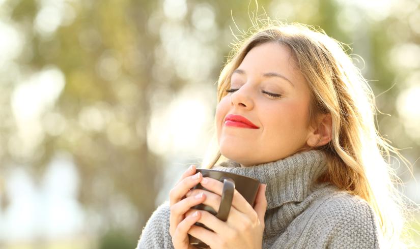 a person drinks coffee outdoors