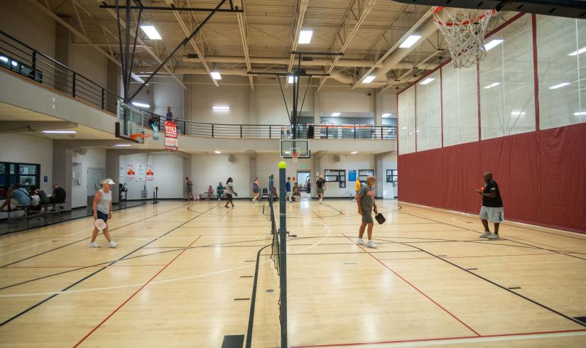 Wide shot of two pickleball courts in the Y's gym