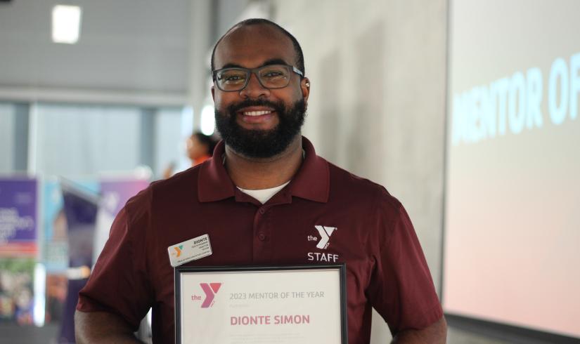 YMCA mentor of the year, Dionte Simon, smiling with his award.