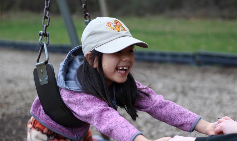 Child care participant plays on the swings at the YMCA