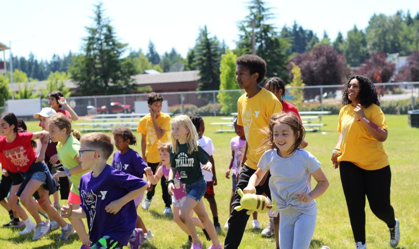 Summer Day Campers running in the field during a camptivity at the YMCA