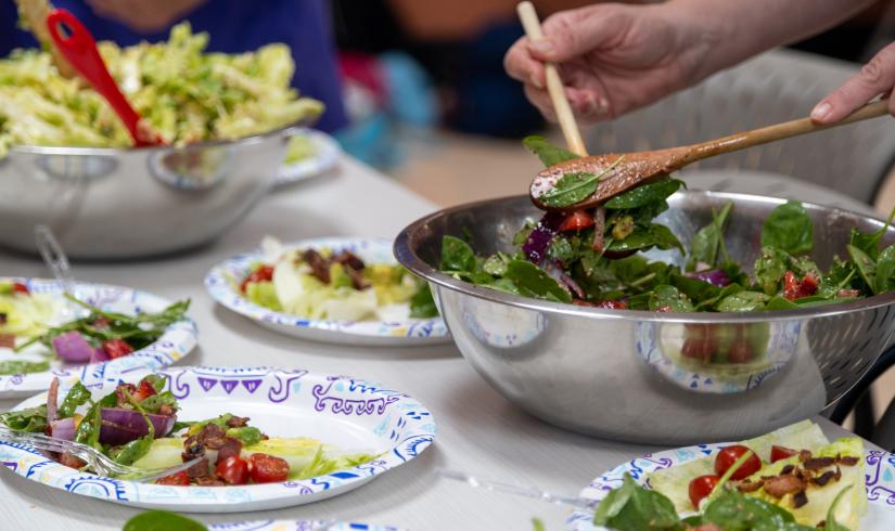 Salad being served at a potluck at Mel Korum Family YMCA