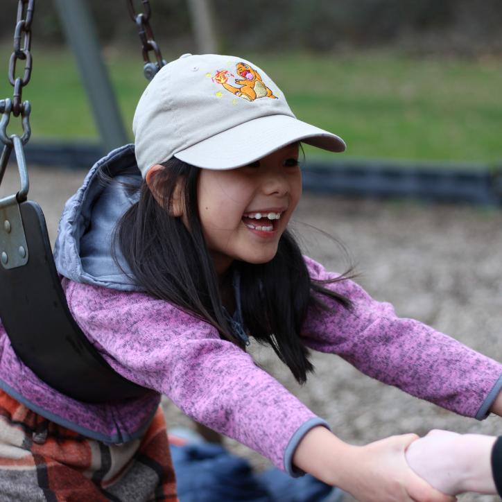 Child care participant plays on the swings at the YMCA