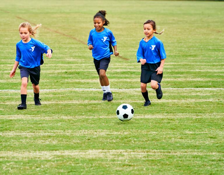 Young Kids Playing Soccer In Blue Uniforms