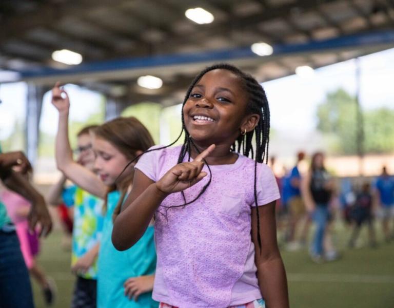 Summer camp participant celebrates a victory during game time at the YMCA