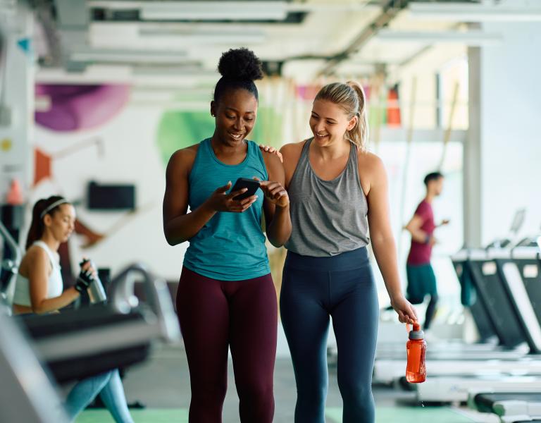 Friends checking workouts on their phone at the YMCA