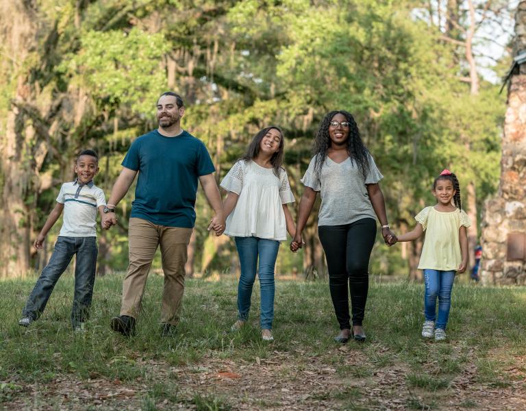 Family Holding Hands In The Park