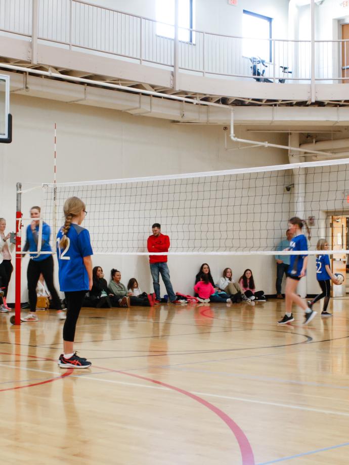 Volleyball players wait for the next serve during a game at the YMCA