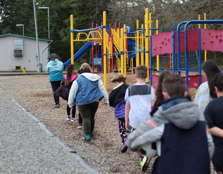 Child care students line up before school to get into the playground at the YMCA before and after school care facility.