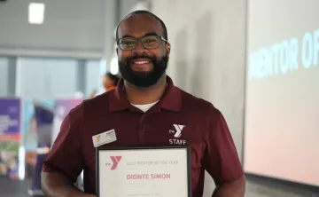 YMCA mentor of the year, Dionte Simon, smiling with his award.