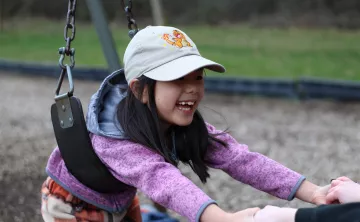 Child care participant plays on the swings at the YMCA