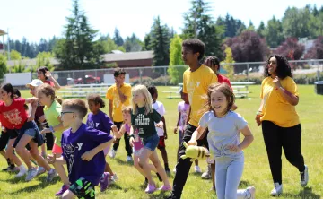 Summer Day Campers running in the field during a camptivity at the YMCA