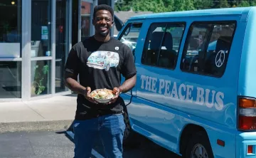 Kwabi with a salad in front of his Peace Bus